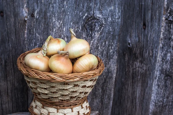 Onions and garlic on a background of aged board with space for writing — Stock Photo, Image