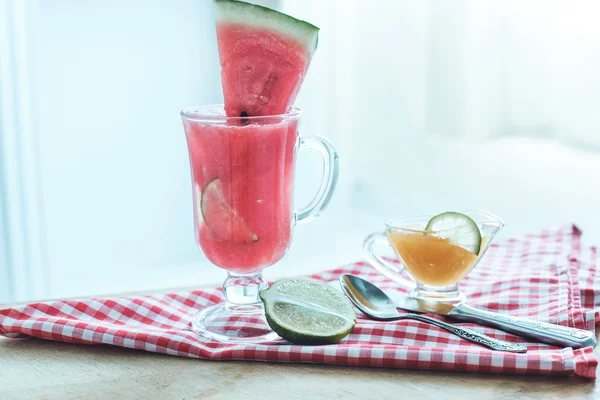 Slice of watermelon and watermelon refreshing cocktail with ice and lime — Stock Photo, Image