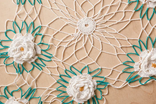 Lace πετσετάκι με λευκά λουλούδια και το πράσινο σε ξύλινα φόντο — Φωτογραφία Αρχείου