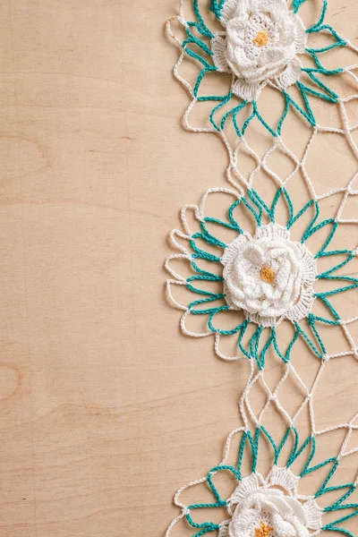 Lace πετσετάκι με λευκά λουλούδια και το πράσινο σε ξύλινα φόντο — Φωτογραφία Αρχείου