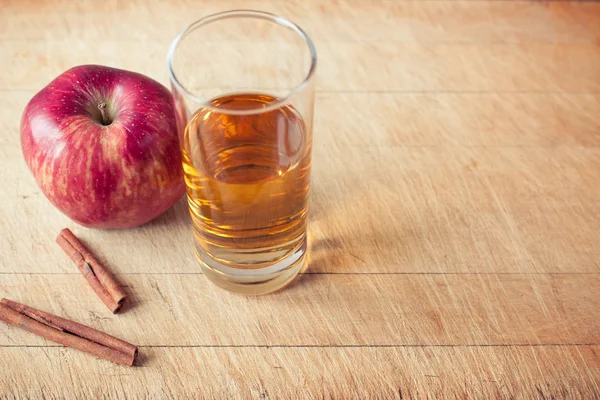 Apel dan segelas jus apel di papan kayu — Stok Foto