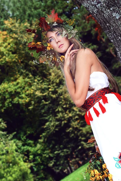 Söt flicka på naturen i höst kransen av löv — Stockfoto