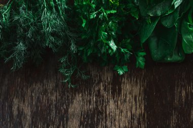 Taze kokulu rezene, maydanoz ve ıspanak ile yer yazmak için ahşap bir yüzeye