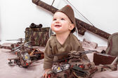 Kind auf weißem Hintergrund mit militärischem Spielzeug