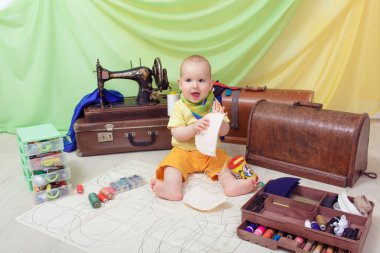 Küçük bebek bir dikiş makinesi, iplik ve makas ile giysi Tasarımcısı