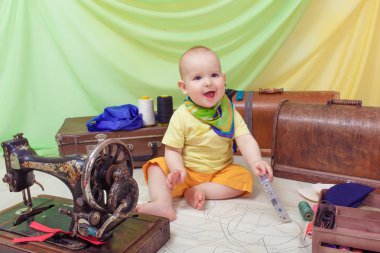 Küçük bebek bir dikiş makinesi, iplik ve makas ile giysi Tasarımcısı