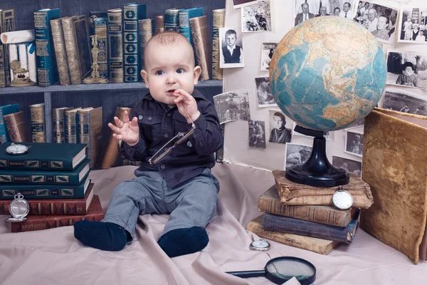 Pequeño niño científico en gafas entre los libros — Foto de Stock