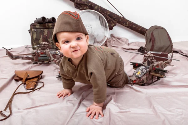 Niño sobre un fondo blanco con juguetes militares — Foto de Stock