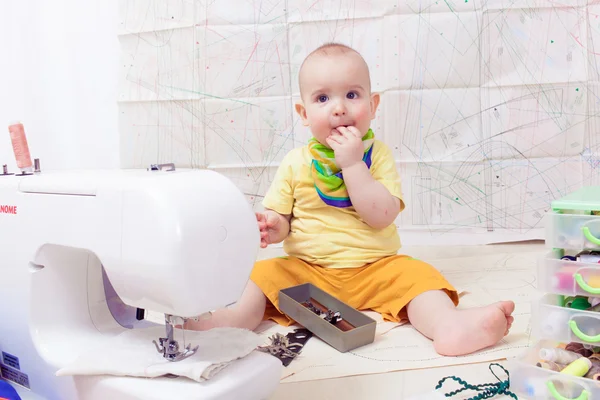 Little baby designer clothes with a sewing machine , thread and scissors — Stock Photo, Image
