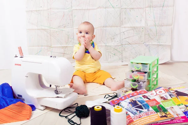 Pequeña ropa de diseño de bebé con una máquina de coser, hilo y tijeras — Foto de Stock