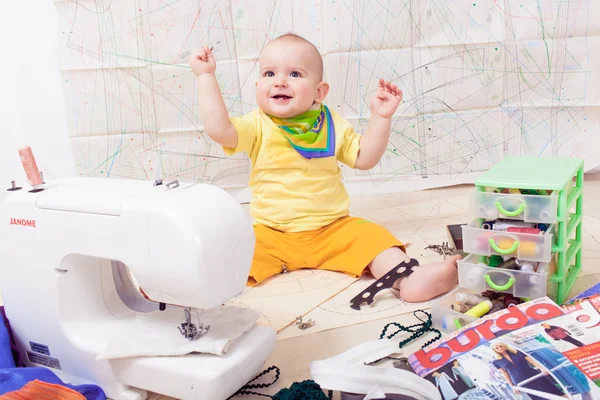 Little baby designer clothes with a sewing machine , thread and scissors — Stock Photo, Image