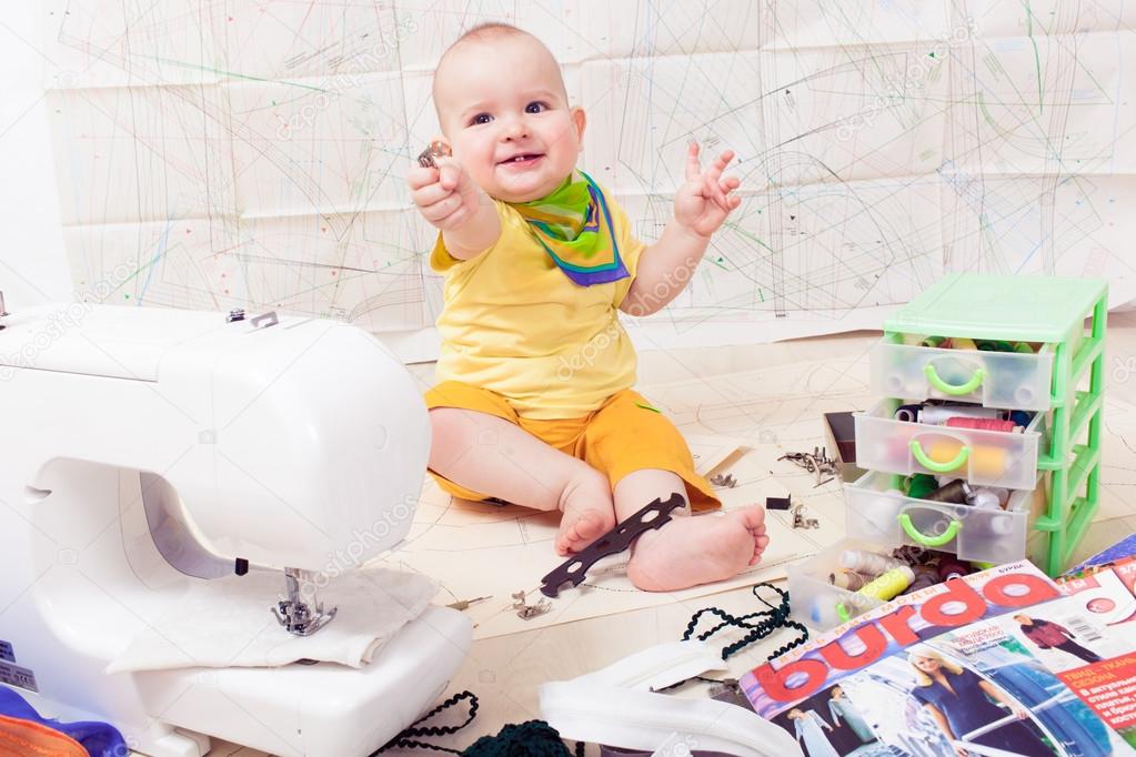 Pequeña ropa de diseño de bebé con una máquina de coser, hilo y