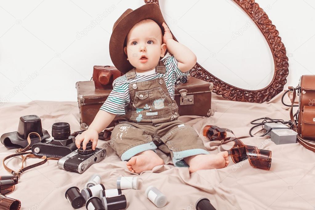 Little baby photographer with a camera and photographic film