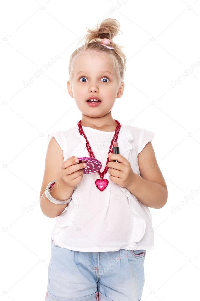 Little girl in fashionable clothes blond fashionista with a mirror and lipstick on a white space for writing
