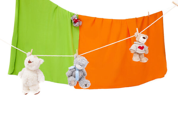 плюшевый мишка на бельевой верёвке на белом
