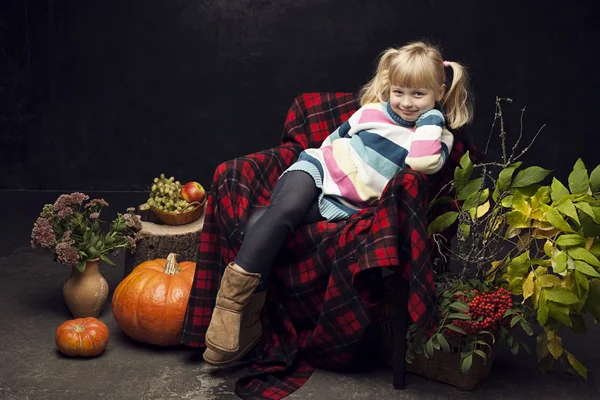 Cheerful girl in the autumn interior on a dark background — Stock Photo, Image