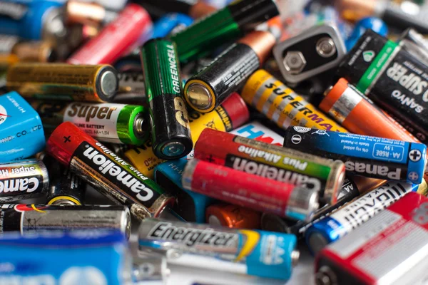 Baterias coloridas de diferentes tamanhos em um fundo branco isolado — Fotografia de Stock