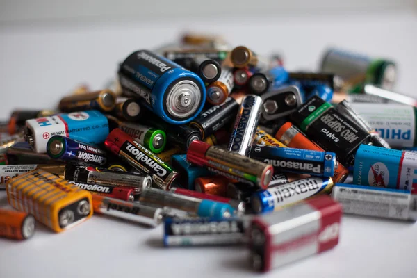 Batterie a colori di diverse dimensioni su uno sfondo bianco isolato — Foto Stock