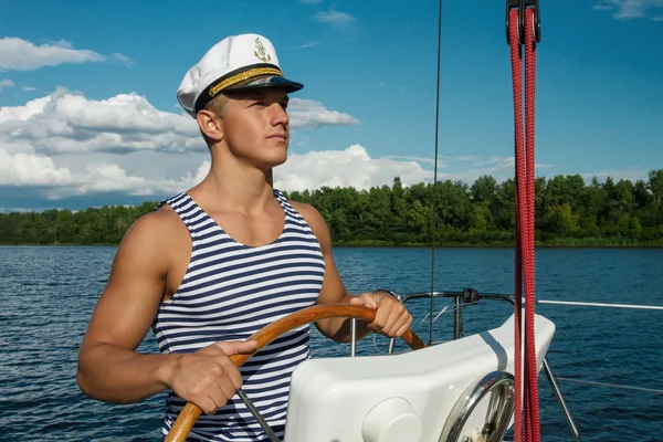 Young man sailor at the helm of yacht. — Stock Photo, Image