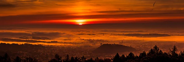 Panorama města Štýrského Hradce zakryté mlhou za podzimního rána při východu slunce. — Stock fotografie