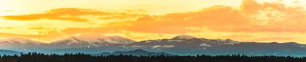 Steirische Lavanttaler Alpen schneebedeckt im orangen Licht des Sonnenuntergangs. — Stockfoto