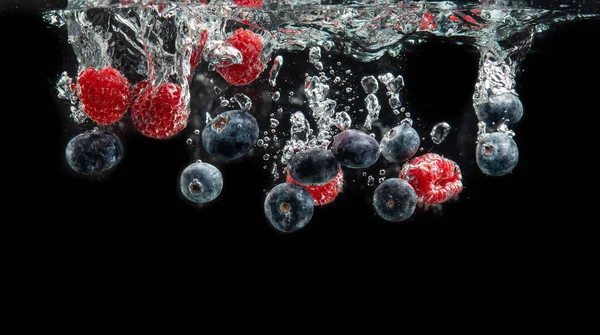 Blaubeeren Und Himbeeren Planschen Kristallklarem Wasser Mit Luftblasen Und Sinkendem — Stockfoto