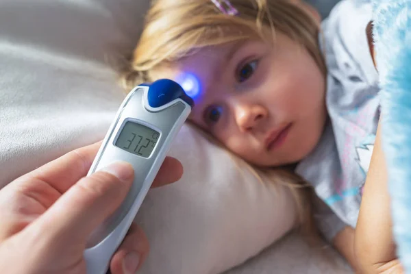 Mutter Nimmt Temperatur Für Ihr Kind Mit Infrarot Thermometer Hause — Stockfoto