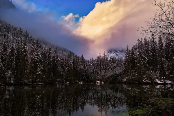 Dramatyczny krajobraz jeziora w lesie w pobliżu gór podczas zimy. — Zdjęcie stockowe