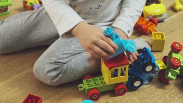 Schattig klein meisje sitson vloer en spelen met kleurrijke bouwstenen. — Stockvideo