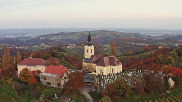 Vista aérea del pueblo austríaco Kitzeck im Sausal en el viñedo. Brote de Iglesia en la cima de la colina de la uva — Vídeo de stock