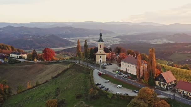 Vista aérea del pueblo austríaco Kitzeck im Sausal en el viñedo. Brote de Iglesia en la cima de la colina de la uva — Vídeo de stock