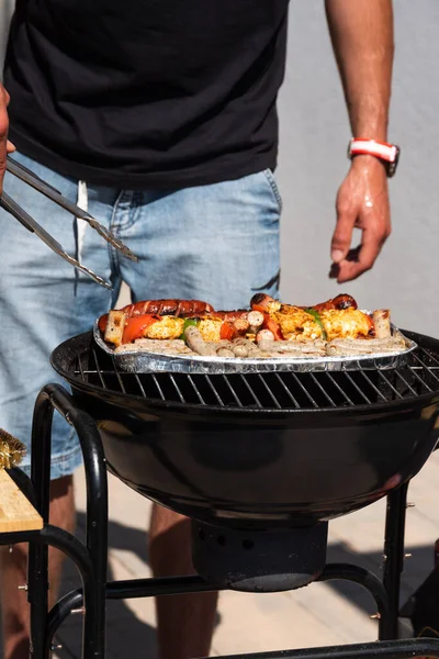 Man standing near BBQ grill look after the food — Stock Photo, Image