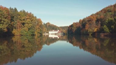 Styria, Thal, Avusturya 'da sonbahar yaprakları ve ağaç yansımalarıyla gölün üzerindeki havadan..