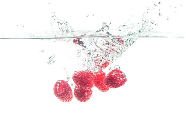 Raspberries splashing in water on white — Stock Photo, Image