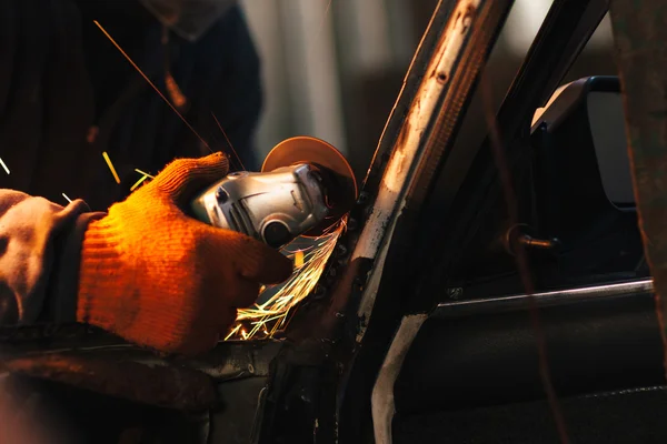 職人は、アングル グラインダーで車を修理します。 — ストック写真