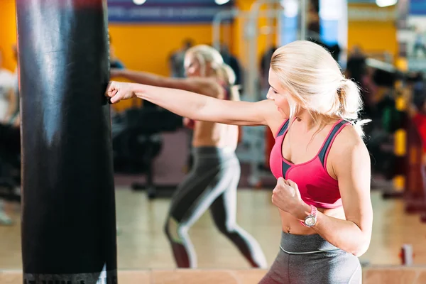 Sportovec silně zasáhne boxovací pytel. — Stock fotografie