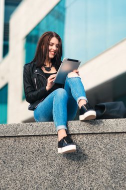 Şehir zemin üzerine tablet ile gülümseyen kız