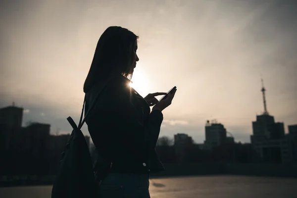 Chica con teléfono en el fondo de la ciudad de noche —  Fotos de Stock
