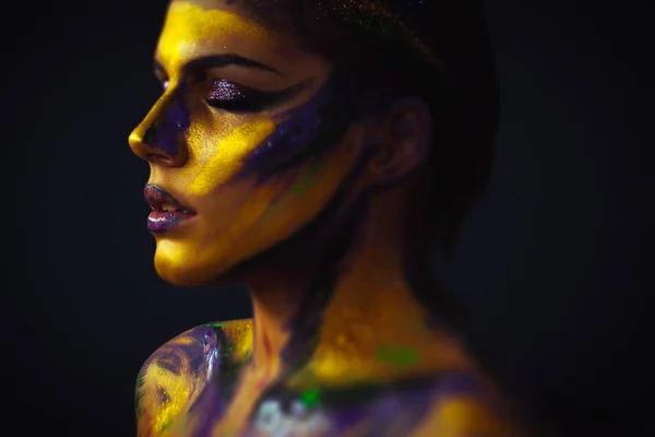 Womans profile body art against black background
