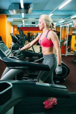 Atletik kızı spor salonunda treadmil ayarlama