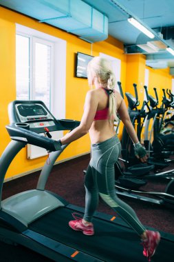 Atletik kız treadmil spor salonunda koşu