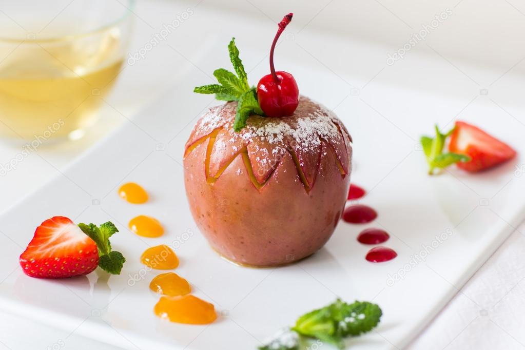 Baked apple with fruit jam on plate