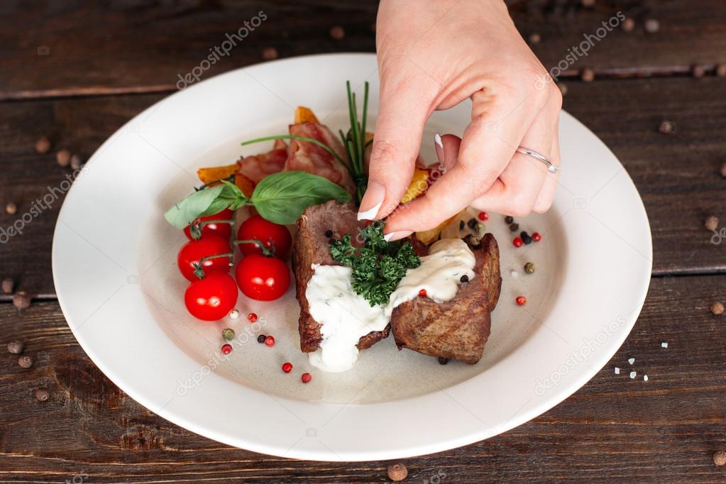 Food decoration. Chief adds spices and herbs