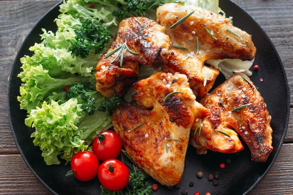Grilled chicken wings with lettuce and tomatoes — Stock Photo, Image