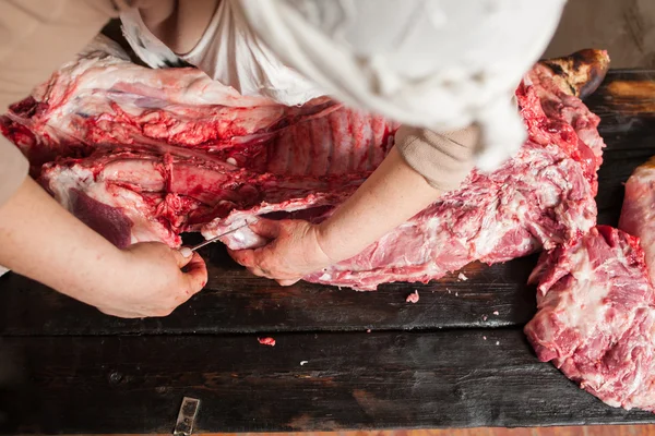 Butcher slicing piece pork carcass. Top view — Stock Photo, Image