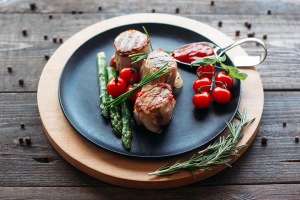 Grilled pork with vegetables on black plate