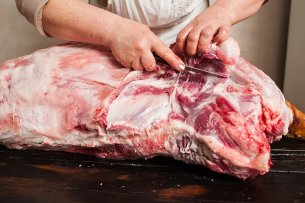 Slaktare carving fläsk slaktkroppar. Karva rått kött — Stockfoto