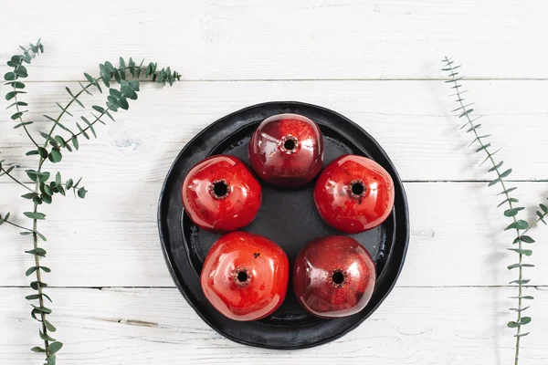 Viele keramische rote Granatäpfel und schwarzer Teller — Stockfoto