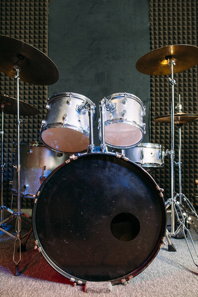 Modern drum set on black stage background prepared for playing. Professional drum kit with some cymbals on stage before a live concert. Drummer, music band, night show, sound recording concept