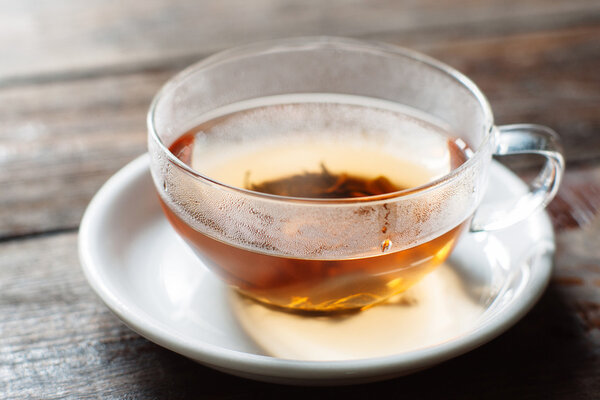 Cup of hot tea on wooden background